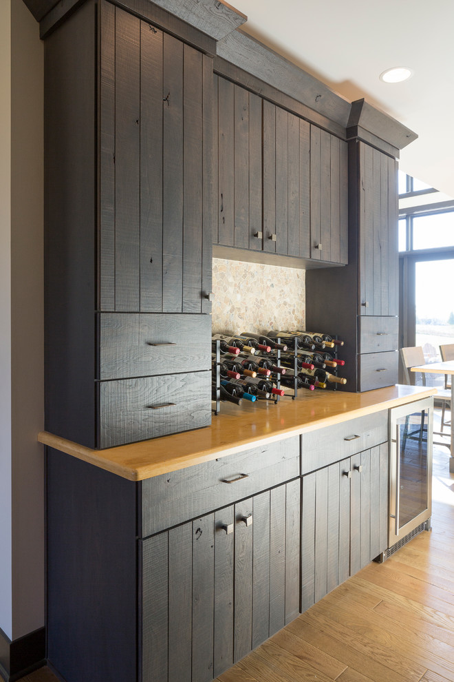 Inspiration for a mid-sized rustic u-shaped light wood floor eat-in kitchen remodel in Cincinnati with flat-panel cabinets, dark wood cabinets, solid surface countertops, multicolored backsplash, stone tile backsplash, stainless steel appliances and an island