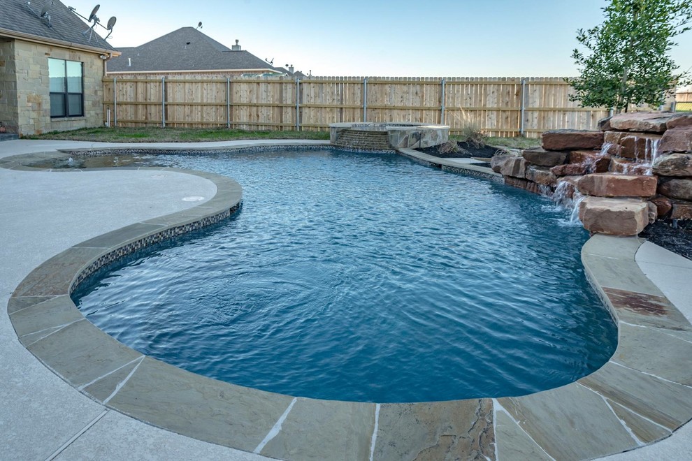 Mid-sized mountain style backyard stone and kidney-shaped natural hot tub photo in Austin
