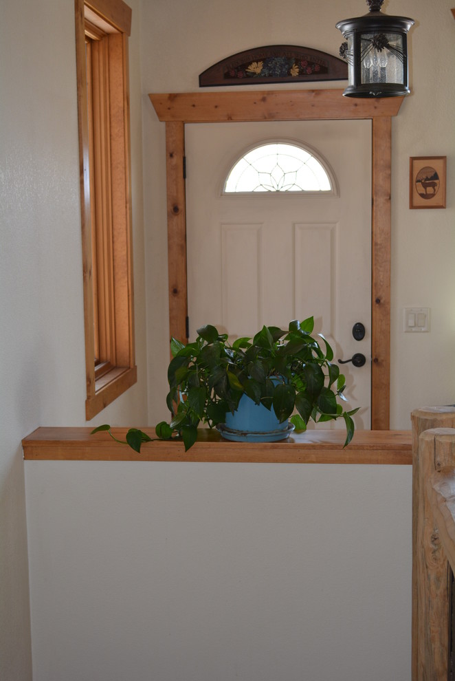 This is an example of a small country foyer in Denver with white walls, ceramic floors, a white front door and a single front door.