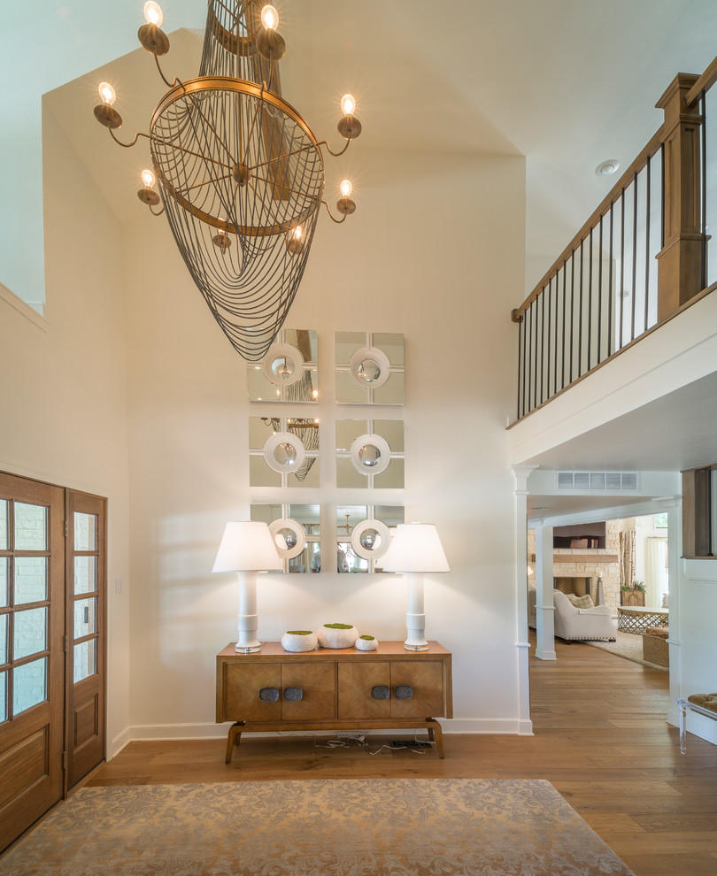 Transitional medium tone wood floor front door photo with white walls and a medium wood front door