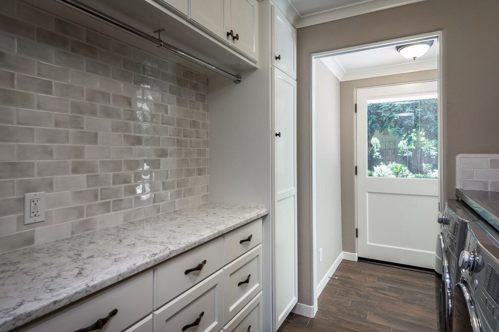 Inspiration for a small contemporary galley dedicated laundry room in Other with an utility sink, shaker cabinets, white cabinets, quartzite benchtops, grey walls, dark hardwood floors, a side-by-side washer and dryer, brown floor and white benchtop.