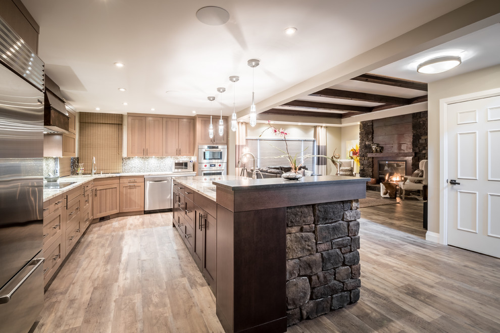 Example of a transitional l-shaped vinyl floor eat-in kitchen design with an undermount sink, shaker cabinets, light wood cabinets, granite countertops, brown backsplash, mosaic tile backsplash, stainless steel appliances and an island