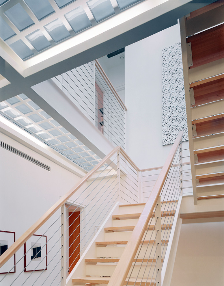 Aménagement d'un grand escalier peint rétro en U avec des marches en bois et un garde-corps en matériaux mixtes.