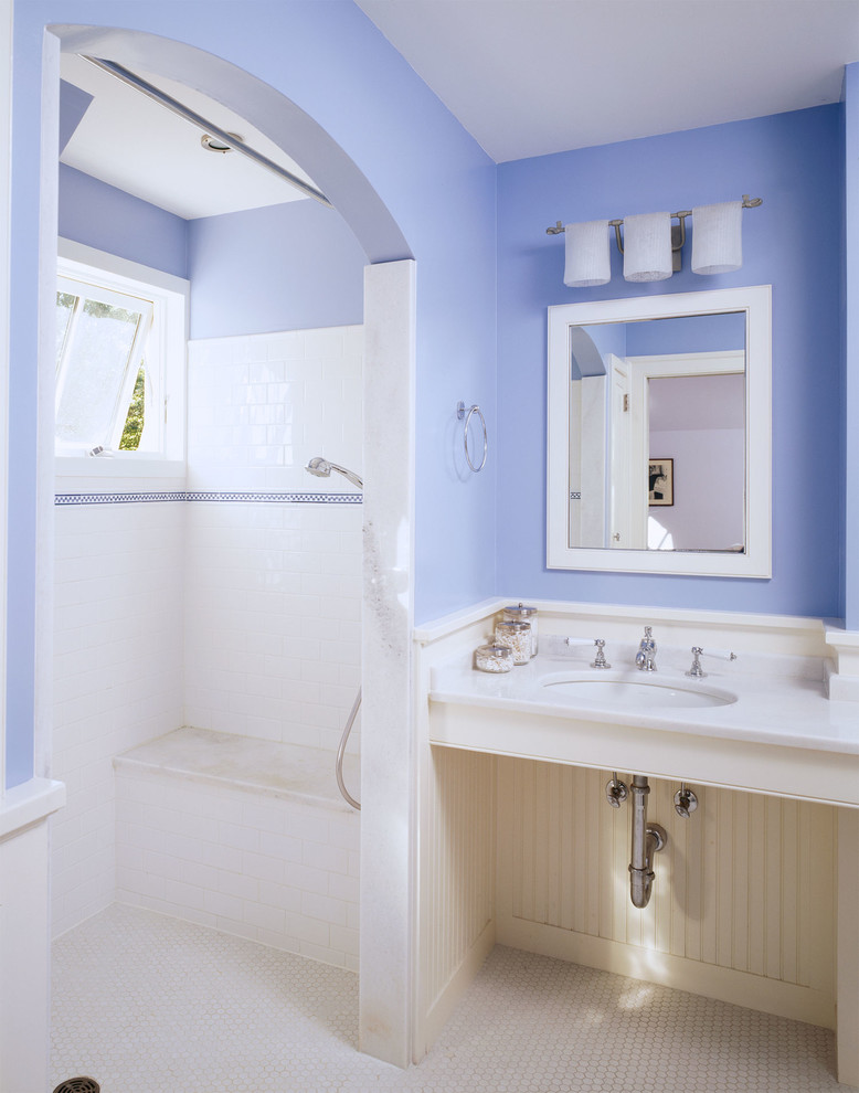This is an example of a mid-sized country 3/4 bathroom in DC Metro with an open shower, blue tile, white tile, subway tile, blue walls, mosaic tile floors, a wall-mount sink, an open shower, open cabinets and white floor.