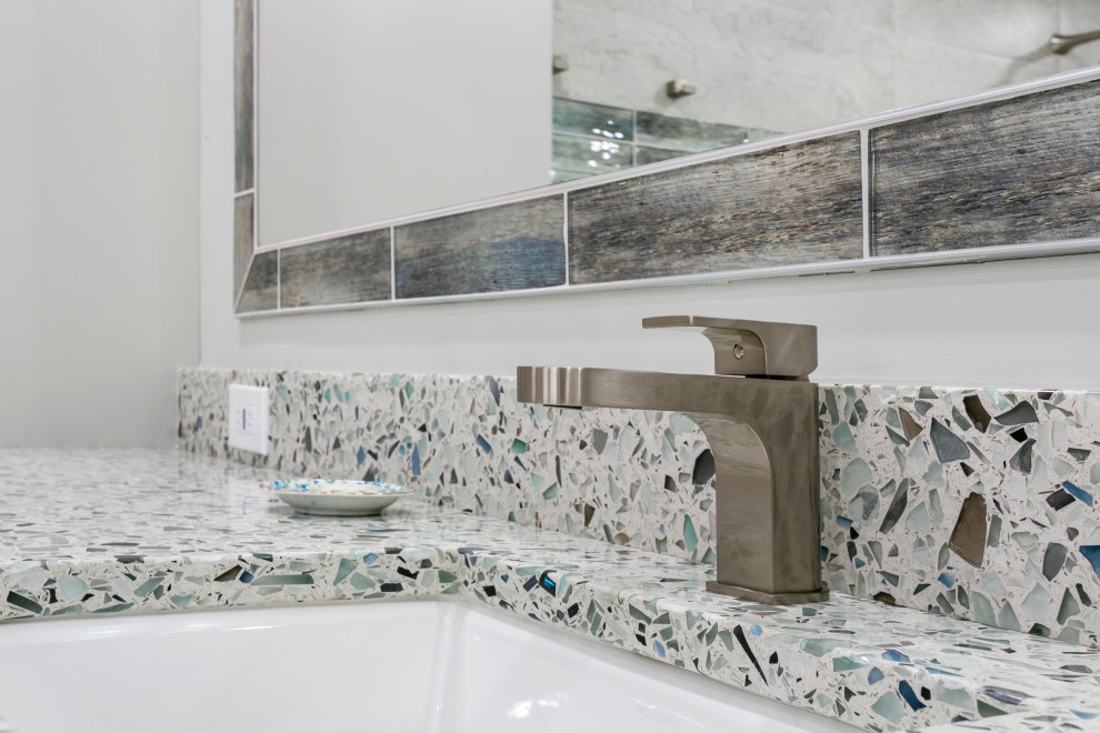 This is an example of a transitional master bathroom in Miami with flat-panel cabinets, grey cabinets, a corner tub, an open shower, a one-piece toilet, grey walls, porcelain floors, an undermount sink, terrazzo benchtops, grey floor, an open shower, multi-coloured benchtops, a shower seat, a double vanity, multi-coloured tile, porcelain tile and a built-in vanity.