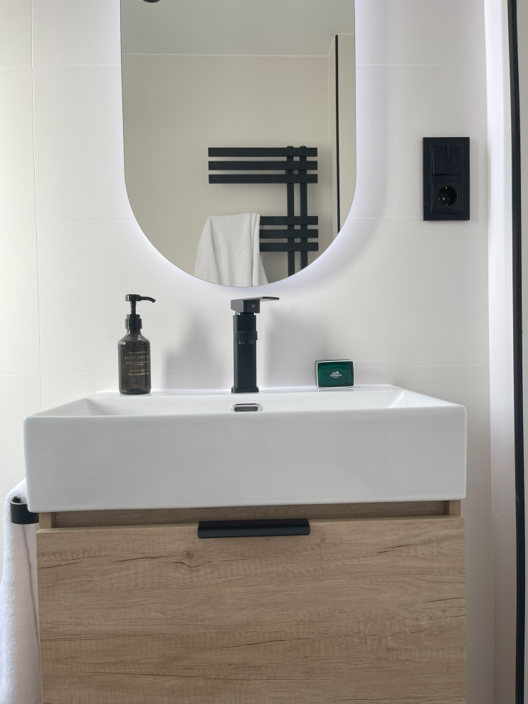 Inspiration for a mid-sized modern master bathroom in Madrid with furniture-like cabinets, light wood cabinets, a one-piece toilet, white tile, white walls, ceramic floors, a vessel sink, terrazzo benchtops, beige floor, a sliding shower screen, white benchtops, a niche, a single vanity, a built-in vanity, recessed and brick walls.