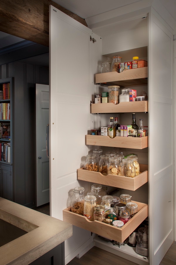 This is an example of an industrial l-shaped kitchen pantry in Philadelphia with white cabinets and with island.