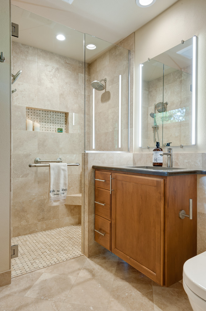 Design ideas for a small traditional master bathroom in Portland with raised-panel cabinets, medium wood cabinets, a curbless shower, a wall-mount toilet, beige tile, travertine, beige walls, travertine floors, an undermount sink, engineered quartz benchtops, multi-coloured floor and a hinged shower door.