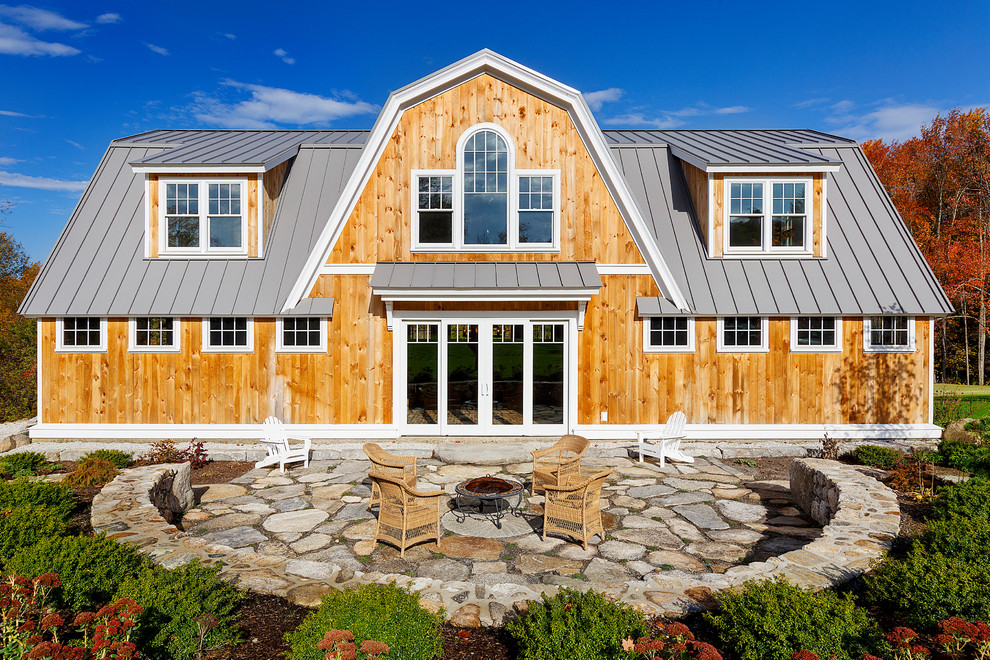 Inspiration for a large country two-storey house exterior in Boston with wood siding, a gambrel roof and a metal roof.