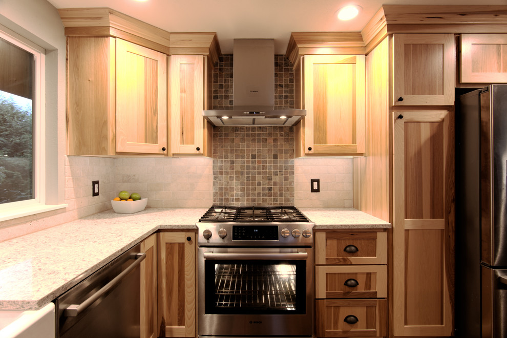 Inspiration for a mid-sized rustic l-shaped medium tone wood floor eat-in kitchen remodel in Seattle with a farmhouse sink, shaker cabinets, light wood cabinets, quartz countertops, beige backsplash, stone tile backsplash, stainless steel appliances and an island