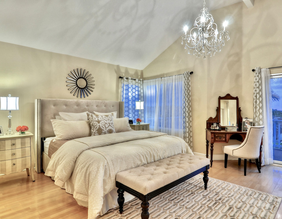 Idée de décoration pour une chambre parentale tradition avec un mur beige, un sol en bois brun et un plafond voûté.