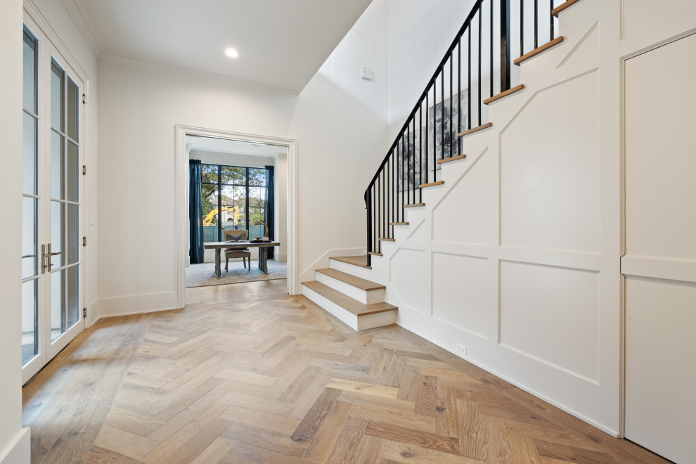 Example of a huge transitional medium tone wood floor foyer design in Houston