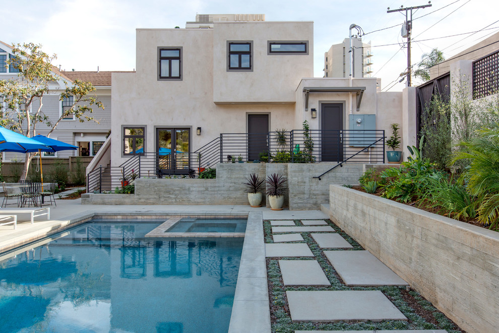 Inspiration for a large modern backyard rectangular lap pool in San Diego with a hot tub and concrete pavers.