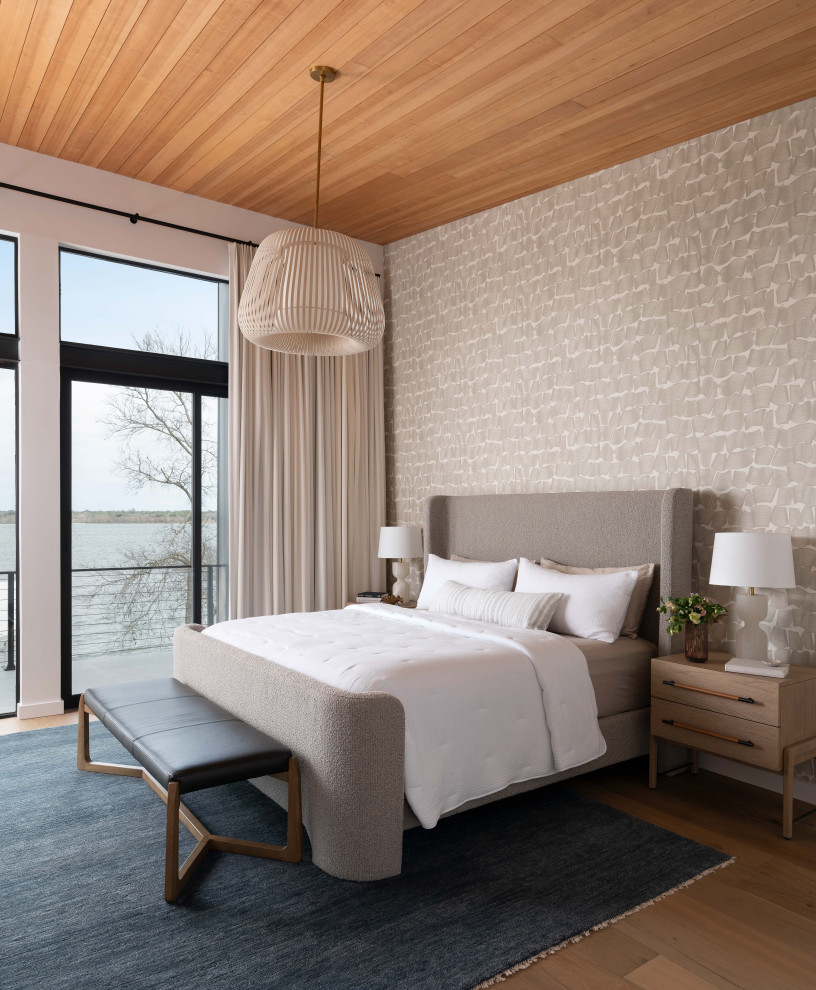Example of a trendy medium tone wood floor, brown floor, wood ceiling and wallpaper bedroom design in Austin with gray walls