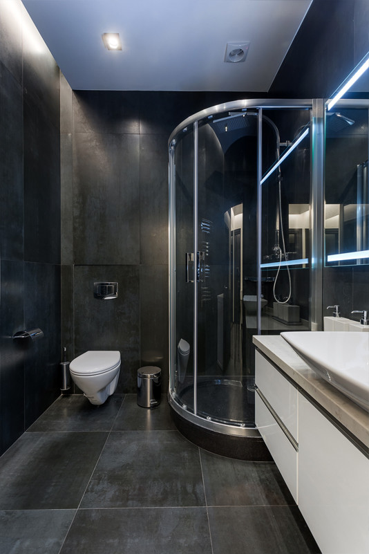 Small contemporary 3/4 bathroom in Moscow with flat-panel cabinets, white cabinets, a corner shower, a wall-mount toilet, black tile, porcelain tile, black walls, porcelain floors, a vessel sink, engineered quartz benchtops, black floor, a sliding shower screen and white benchtops.