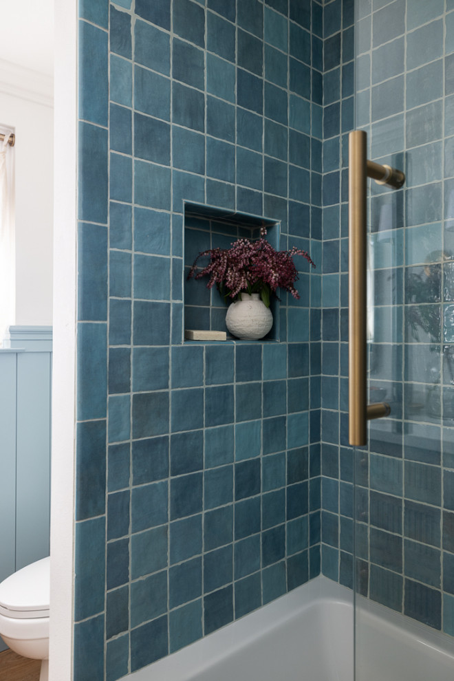 Inspiration pour une salle de bain rustique en bois brun de taille moyenne avec un placard à porte affleurante, une baignoire posée, un combiné douche/baignoire, un carrelage bleu, des carreaux de céramique, un mur bleu, un sol en vinyl, un plan de toilette en quartz modifié, une cabine de douche à porte coulissante, un plan de toilette blanc, une niche, meuble double vasque et meuble-lavabo encastré.