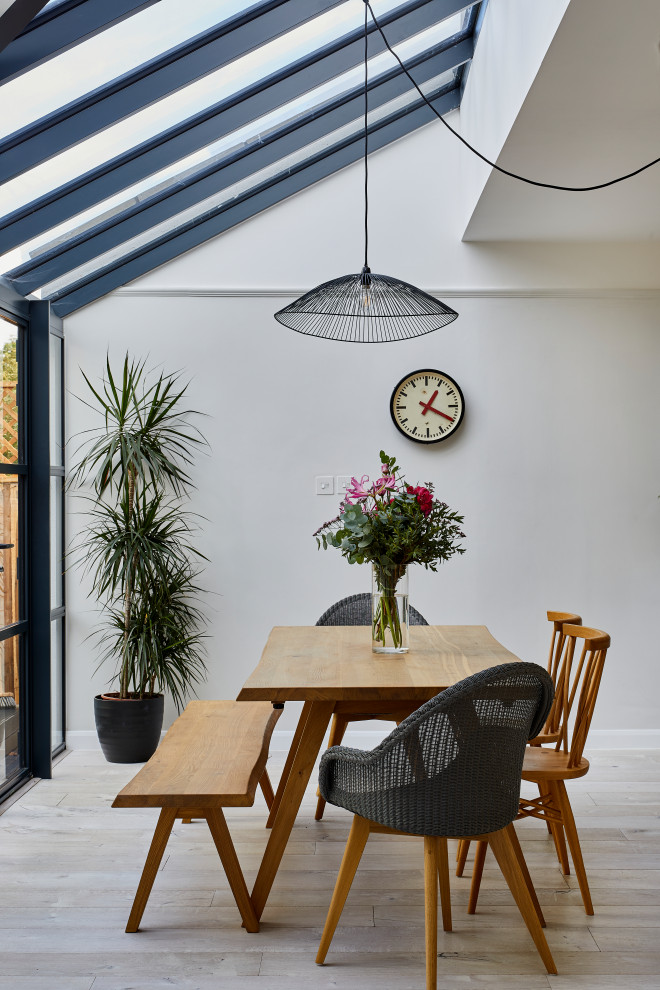 Inspiration for a mid-sized contemporary dining room in Hertfordshire with white walls and beige floor.