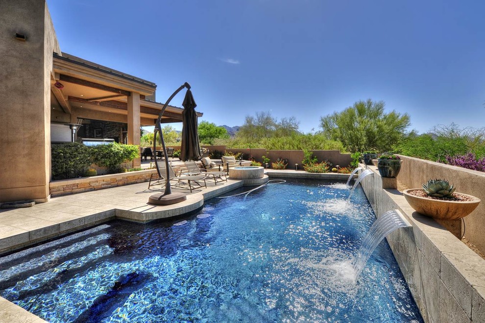 Photo of a contemporary lap pool in Phoenix with a water feature.