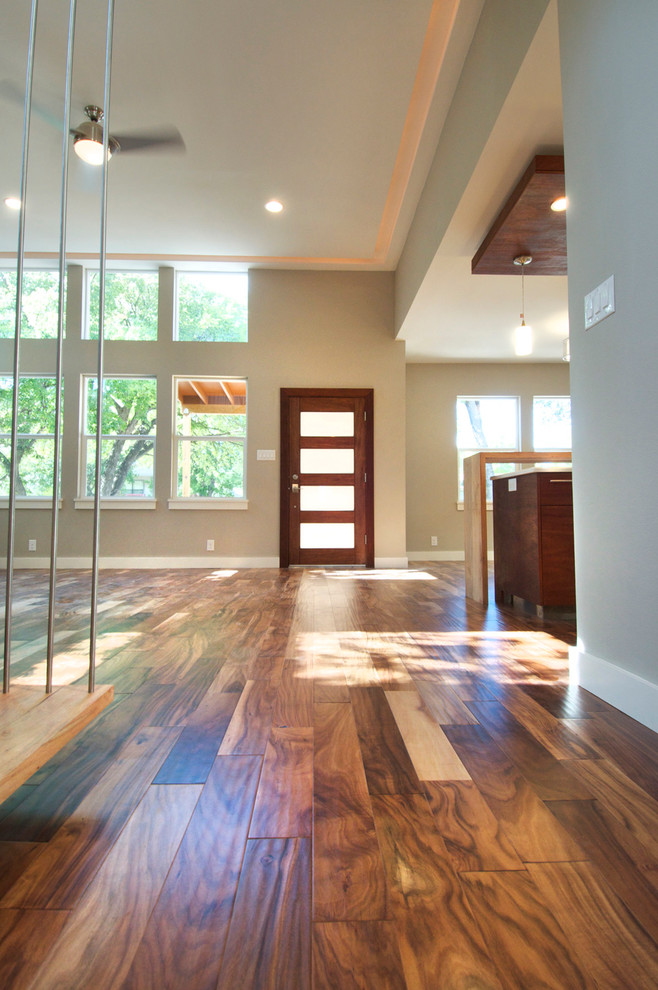 This is an example of a mid-sized contemporary front door in Austin with metallic walls, dark hardwood floors, a single front door and a dark wood front door.