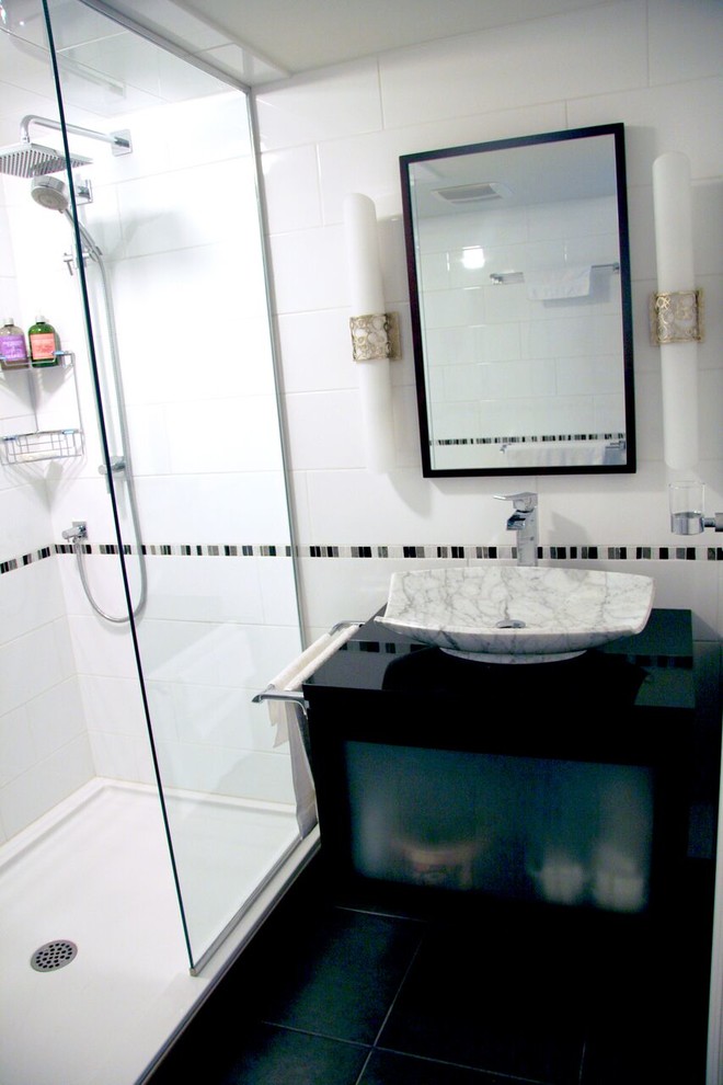 Mid-sized transitional 3/4 white tile and porcelain tile porcelain tile and black floor alcove shower photo with black cabinets, beige walls, a vessel sink, quartz countertops, a hinged shower door and black countertops