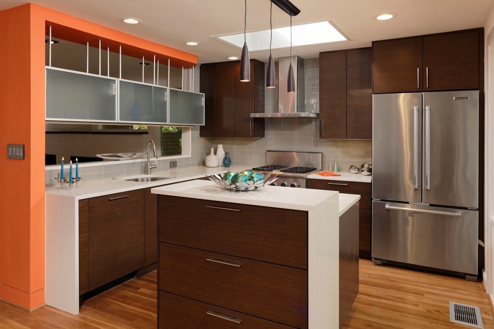 Mid-sized contemporary l-shaped eat-in kitchen in DC Metro with an undermount sink, flat-panel cabinets, dark wood cabinets, quartz benchtops, beige splashback, glass tile splashback, stainless steel appliances, light hardwood floors and with island.