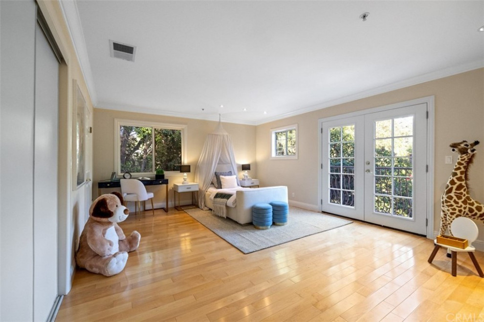 Large modern loft-style bedroom in Los Angeles with beige walls, brown floor, light hardwood floors and recessed.