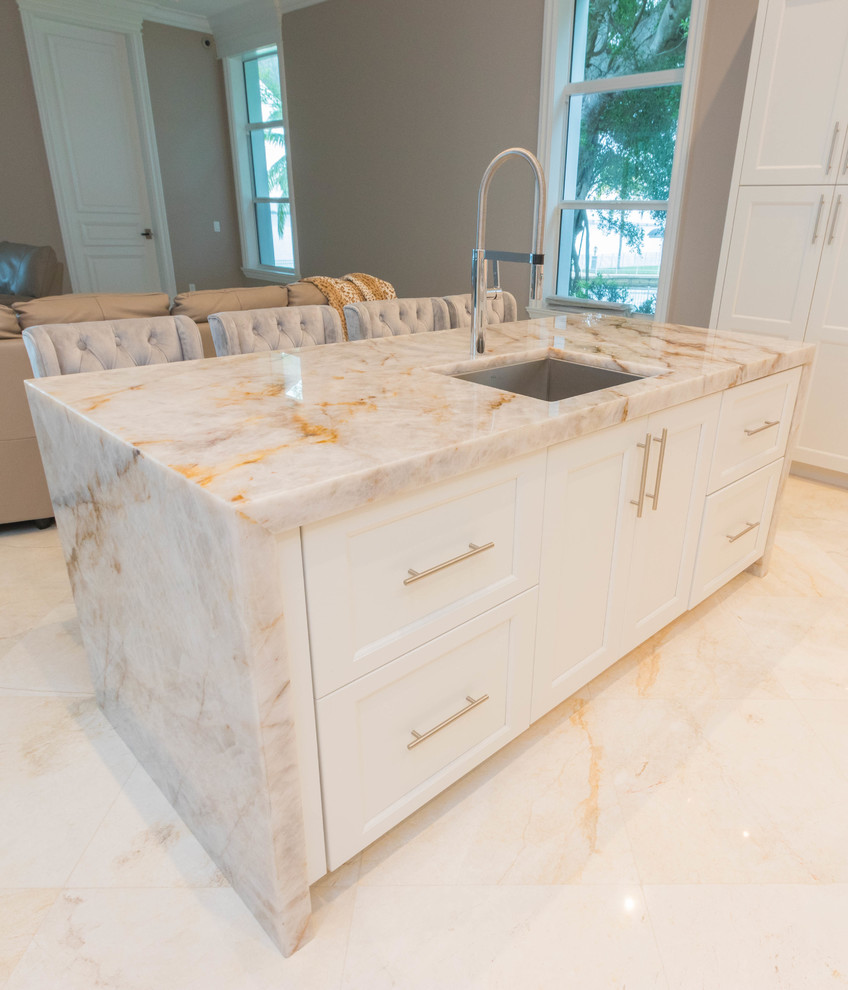 Inspiration for an expansive transitional u-shaped open plan kitchen in Other with an undermount sink, flat-panel cabinets, white cabinets, quartzite benchtops, white splashback, stone slab splashback, marble floors, multiple islands and white floor.