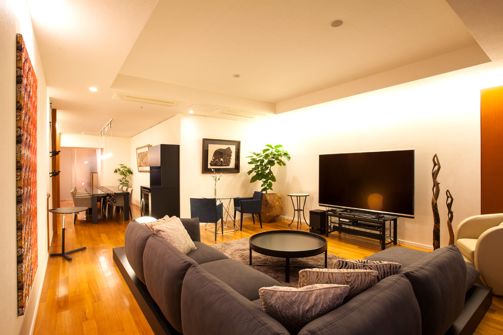 This is an example of a large contemporary living room in Other with white walls and brown floor.