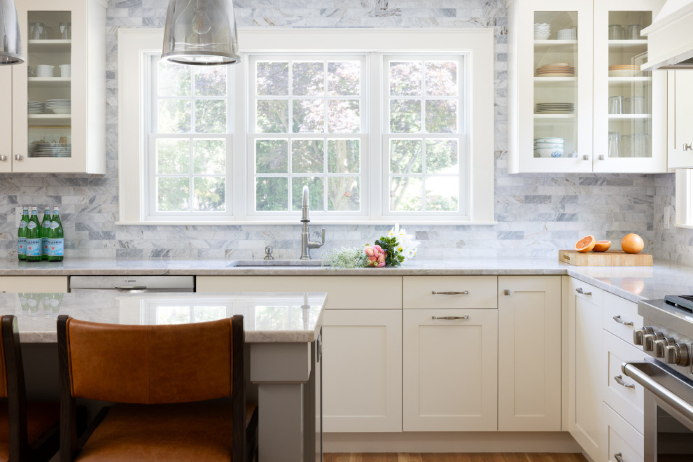 Example of a kitchen design in Boston with shaker cabinets, beige cabinets, quartzite countertops, marble backsplash, an island and gray countertops
