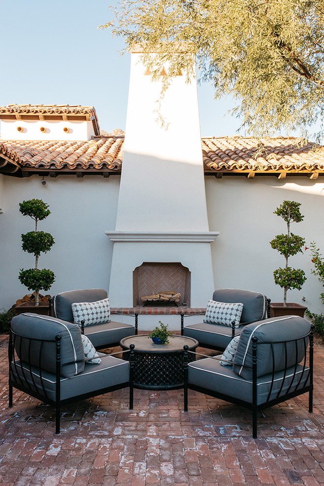 Large mediterranean backyard patio in Phoenix with a fire feature, brick pavers and no cover.