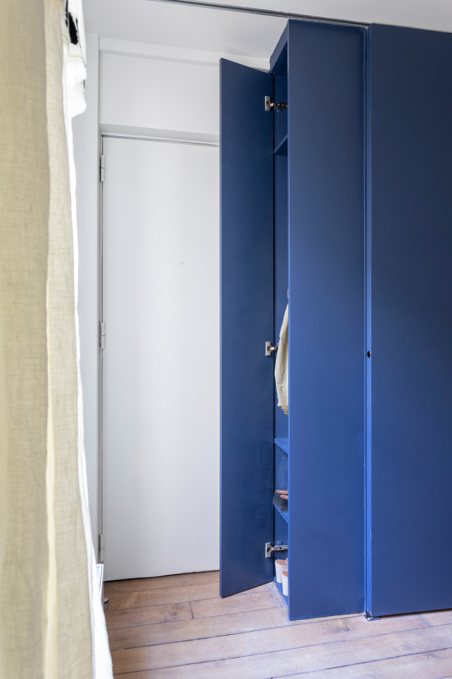 This is an example of a small contemporary front door in Other with blue walls, light hardwood floors, a single front door, a white front door, brown floor and recessed.