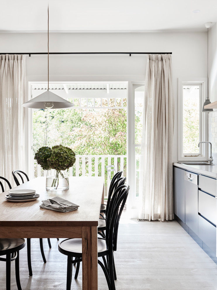 Inspiration for a mid-sized scandinavian kitchen/dining combo in Melbourne with white walls and light hardwood floors.
