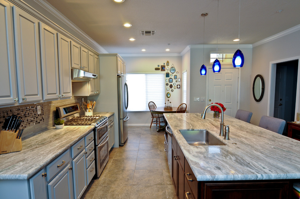 This is an example of a mid-sized traditional galley eat-in kitchen in San Francisco with with island, grey cabinets, multi-coloured splashback, mosaic tile splashback, stainless steel appliances, an undermount sink and ceramic floors.