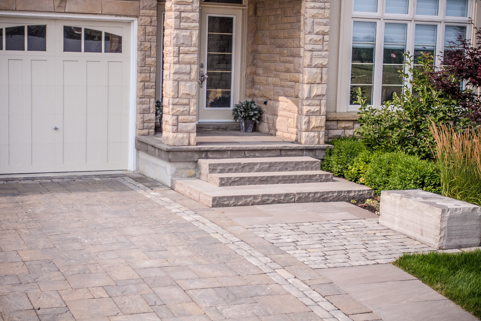 Inspiration for a mid-sized transitional partial sun front yard brick driveway in Toronto for summer.