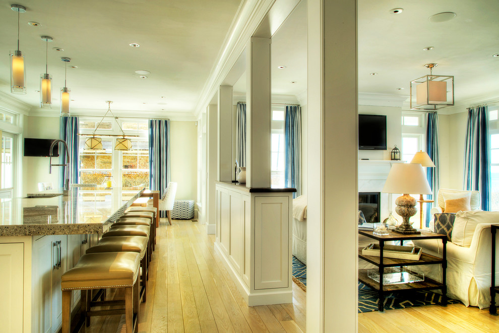 Example of a large transitional single-wall light wood floor and beige floor open concept kitchen design in Providence with a farmhouse sink, beaded inset cabinets, white cabinets, granite countertops, beige backsplash, mosaic tile backsplash, stainless steel appliances and an island