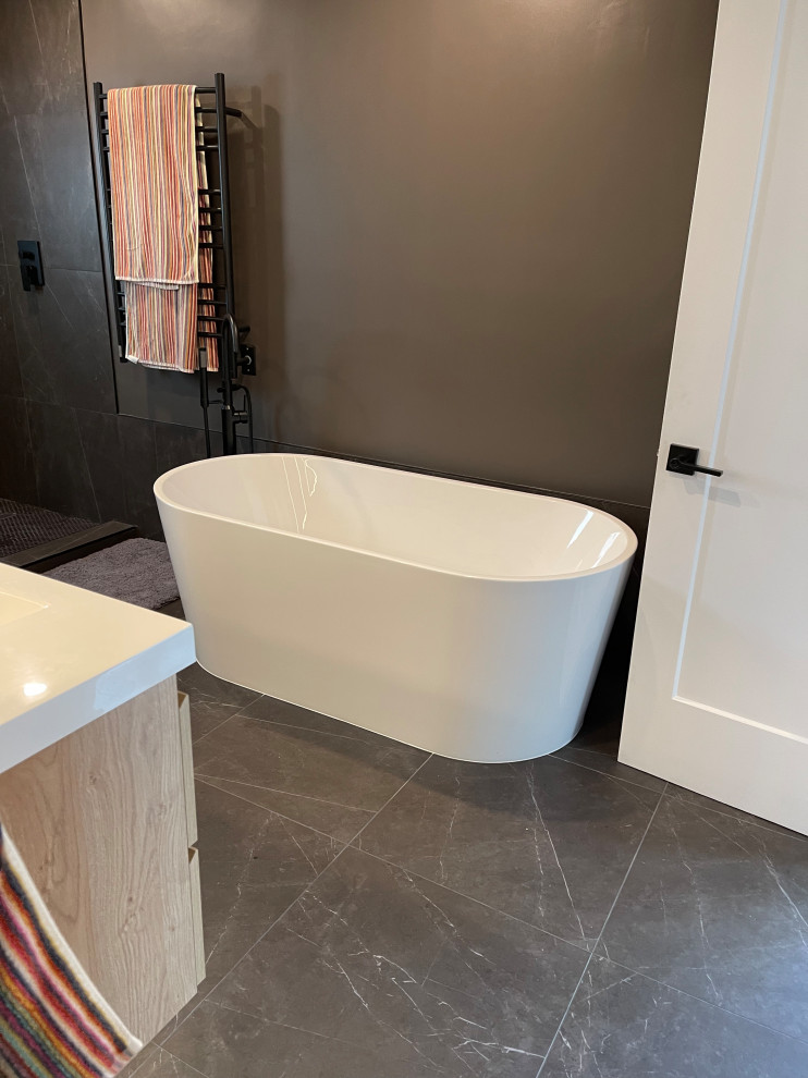 Immagine di una grande stanza da bagno padronale minimalista con ante in legno chiaro, vasca freestanding, doccia aperta, piastrelle nere, pareti nere, top bianco, due lavabi e mobile bagno sospeso