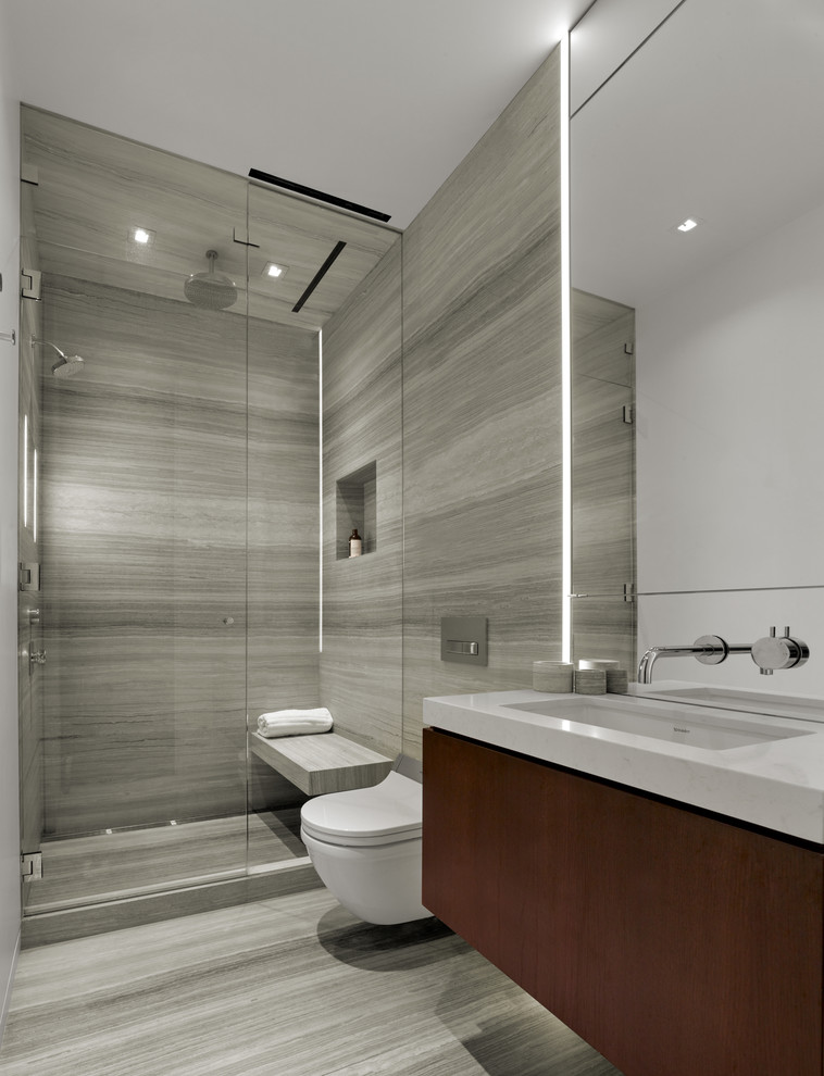 Photo of a small contemporary master bathroom in San Francisco with flat-panel cabinets, dark wood cabinets, an open shower, a wall-mount toilet, beige tile, stone slab, beige walls, limestone floors, an undermount sink and engineered quartz benchtops.