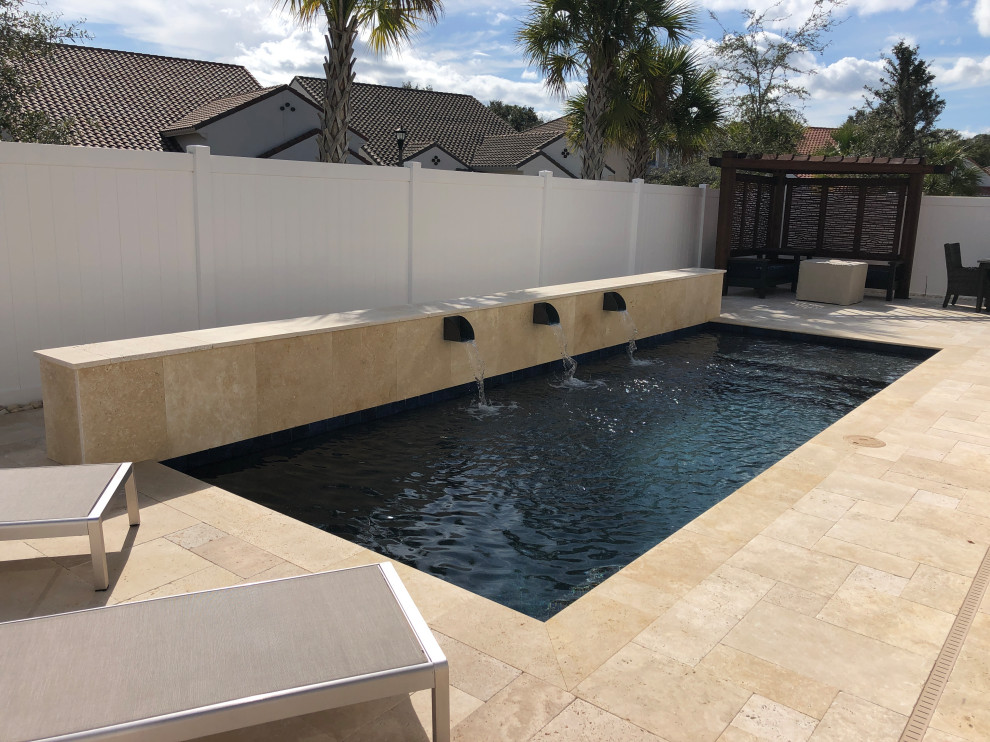 На фото: маленький прямоугольный бассейн на заднем дворе в стиле модернизм с покрытием из каменной брусчатки для на участке и в саду