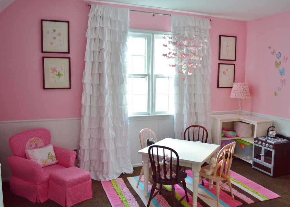 Photo of a mid-sized traditional kids' room for girls in New York with pink walls and dark hardwood floors.