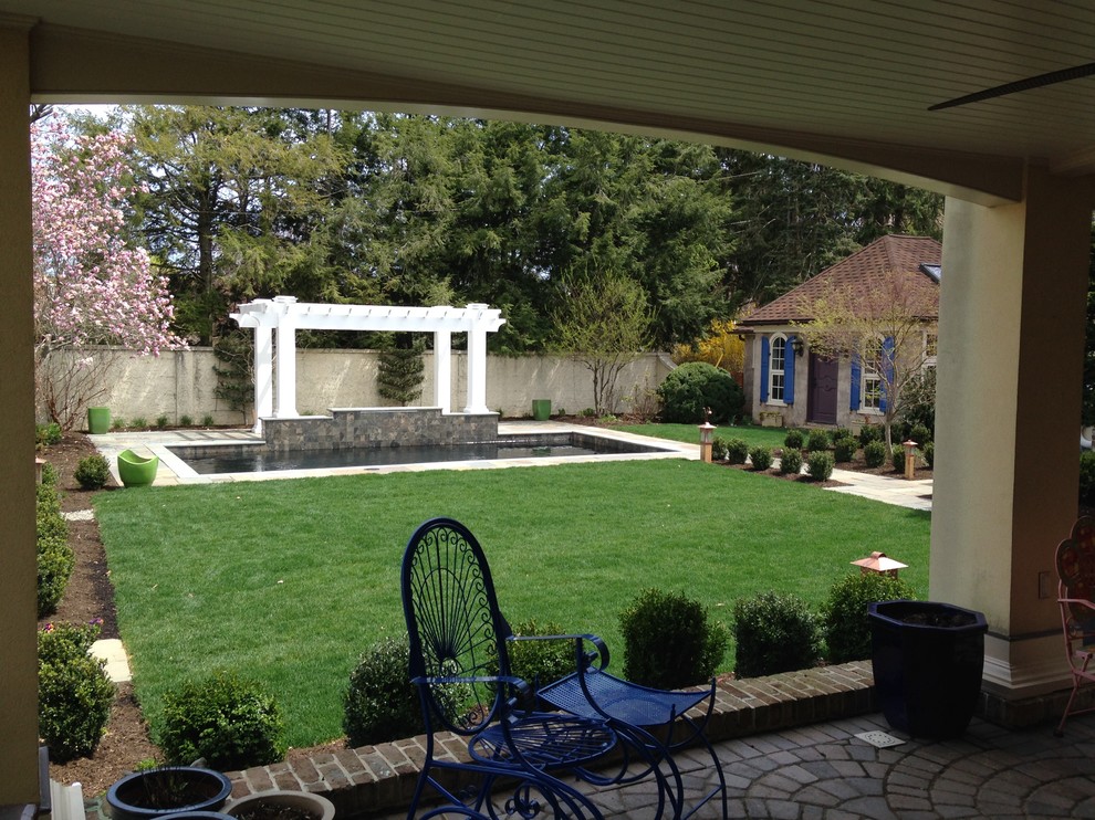 Large traditional backyard partial sun garden in Philadelphia with natural stone pavers.