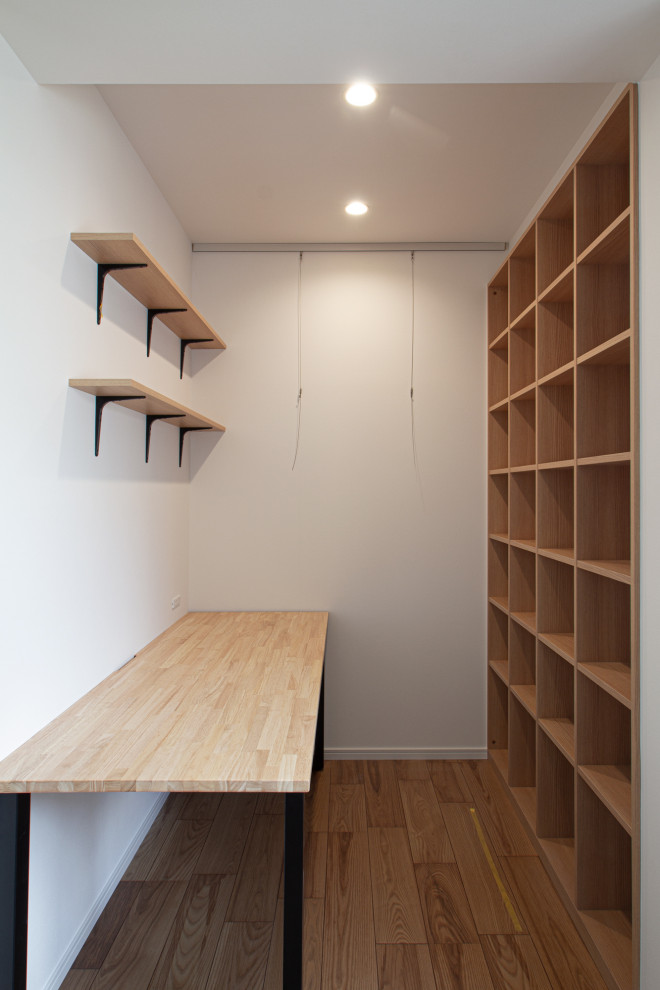 This is an example of a medium sized scandinavian study in Tokyo with purple walls, medium hardwood flooring, no fireplace, a built-in desk, beige floors, a wallpapered ceiling and wallpapered walls.