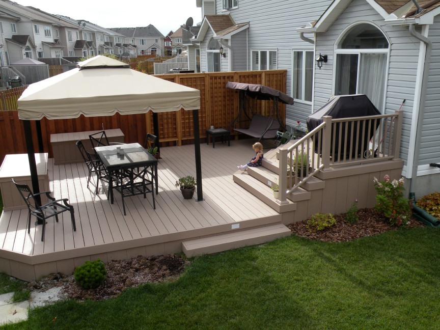 This is an example of a mid-sized modern backyard deck in Toronto.