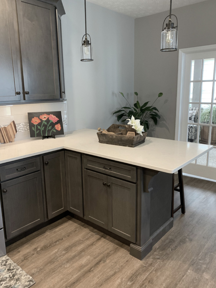 Inspiration for a large transitional u-shaped vinyl floor and gray floor open concept kitchen remodel with an undermount sink, shaker cabinets, gray cabinets, quartz countertops, gray backsplash, ceramic backsplash, stainless steel appliances, a peninsula and white countertops