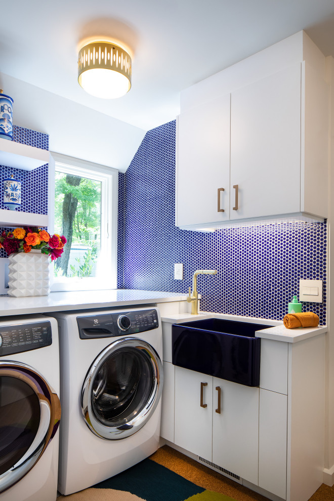 Design ideas for a midcentury laundry room in Philadelphia with a farmhouse sink, flat-panel cabinets, quartz benchtops, blue splashback, ceramic splashback, blue walls, cork floors, a side-by-side washer and dryer and white benchtop.