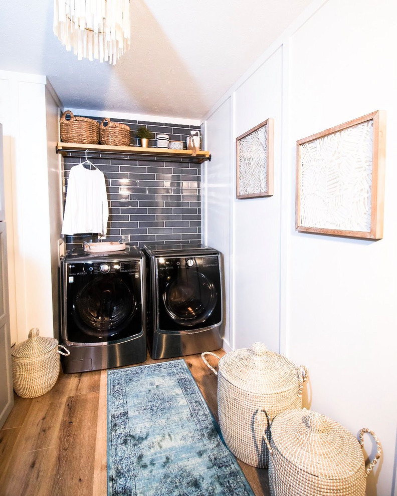Design ideas for a small modern galley dedicated laundry room in Indianapolis with open cabinets, wood benchtops, blue walls, a side-by-side washer and dryer and brown floor.