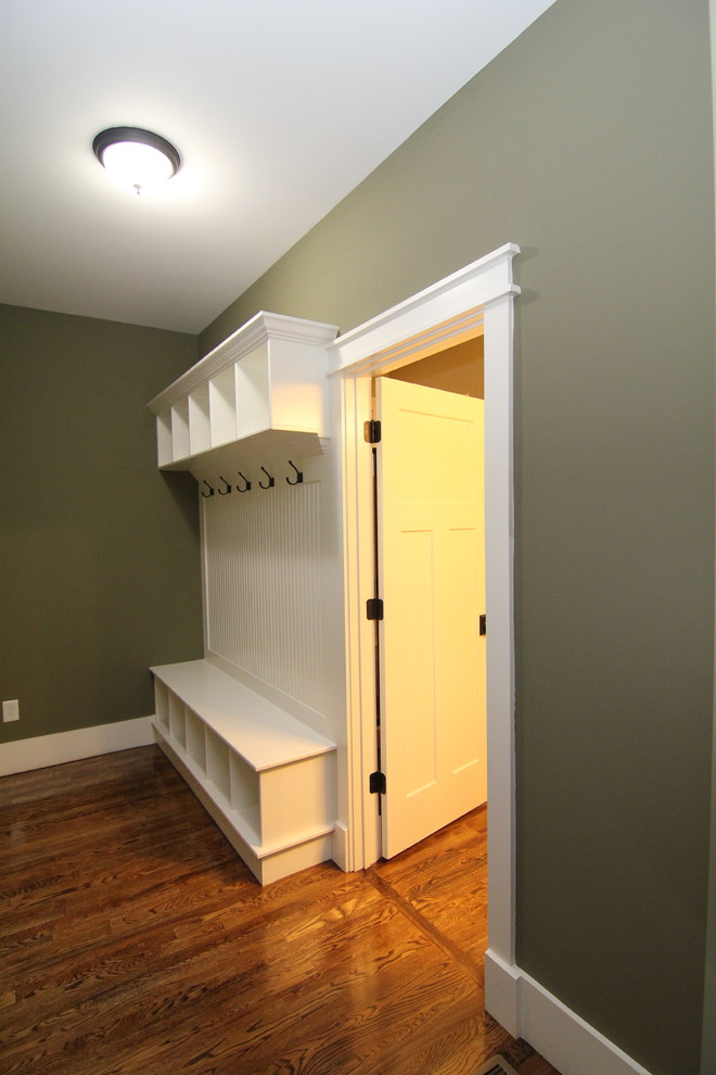 Small transitional hallway in Raleigh with dark hardwood floors and green walls.