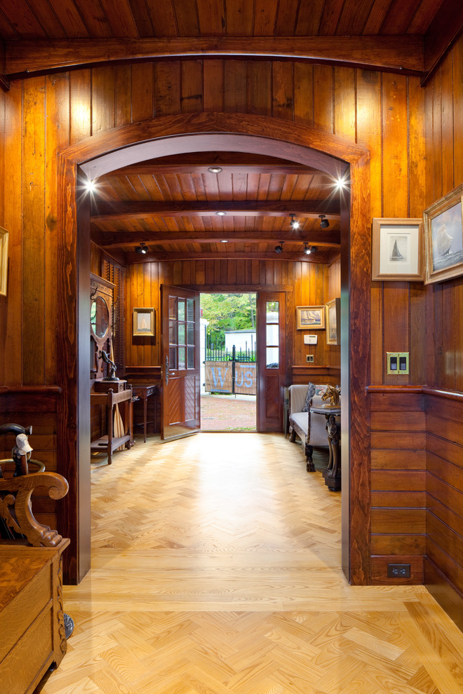 This is an example of a large eclectic vestibule in Providence with brown walls and light hardwood floors.