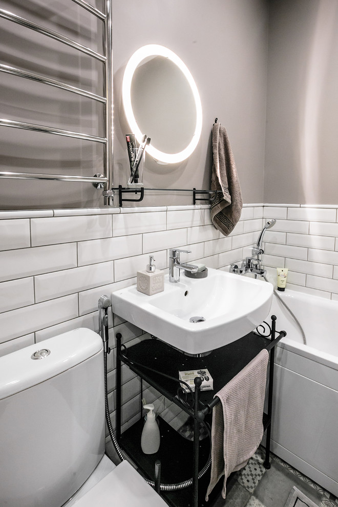Photo of a small scandinavian master bathroom in Other with open cabinets, an alcove tub, a shower/bathtub combo, white tile, subway tile, grey walls, a wall-mount sink and grey floor.
