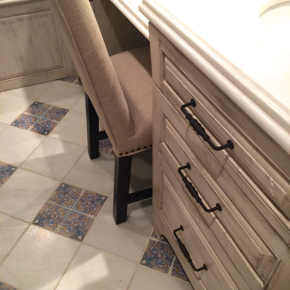 Inspiration for a mid-sized transitional master blue tile and porcelain tile ceramic tile and blue floor wet room remodel with raised-panel cabinets, distressed cabinets, an undermount tub, beige walls, an undermount sink, solid surface countertops and a hinged shower door