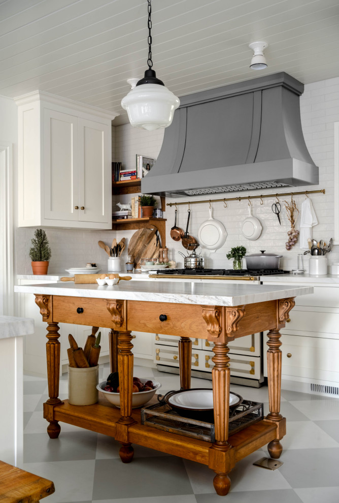 Inspiration for a mid-sized u-shaped eat-in kitchen in Toronto with a farmhouse sink, recessed-panel cabinets, white cabinets, marble benchtops, white splashback, subway tile splashback, panelled appliances, light hardwood floors, multiple islands, grey floor, white benchtop and timber.